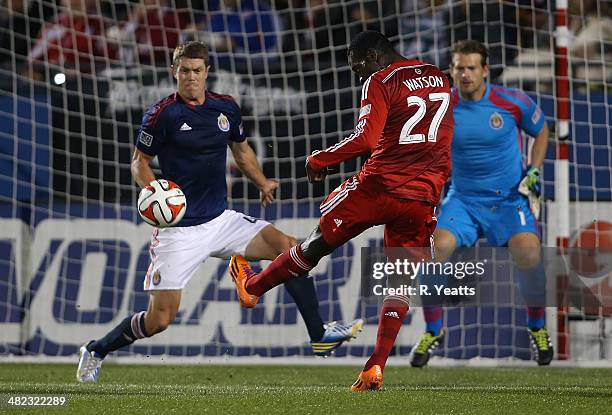 Je-Vaughn Watson of FC Dallas attempts a goal around Tony Lochhead of Chivas USA and past goalie Dan Kennedy at Toyota Stadium on March 22, 2014 in...