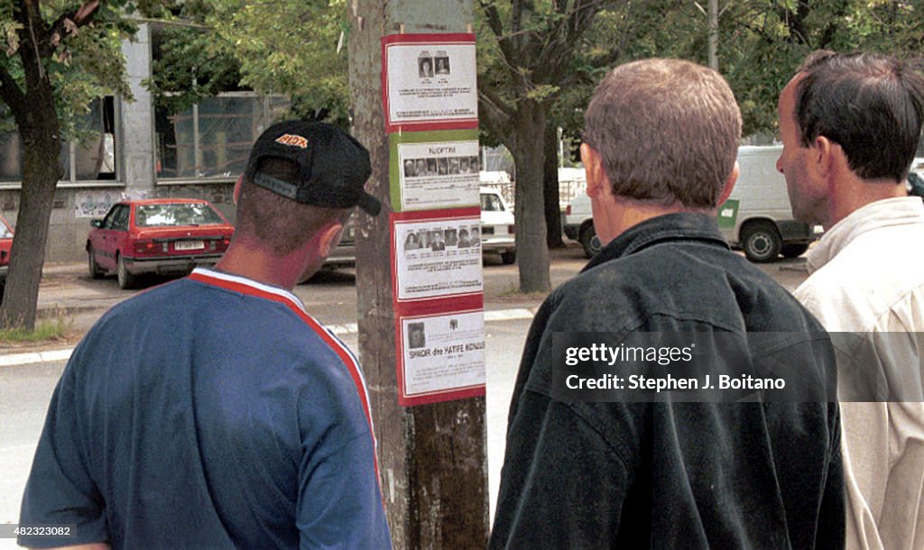 Albanian men read death notices in Pristina, Kosovo after...