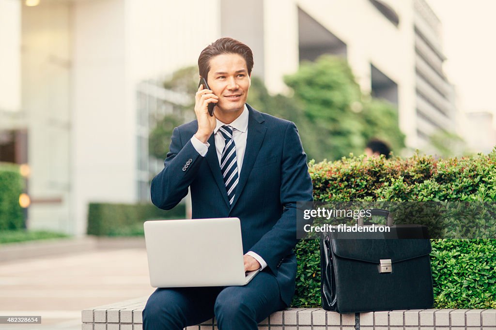 Young mixed ethnicity businessman working outside