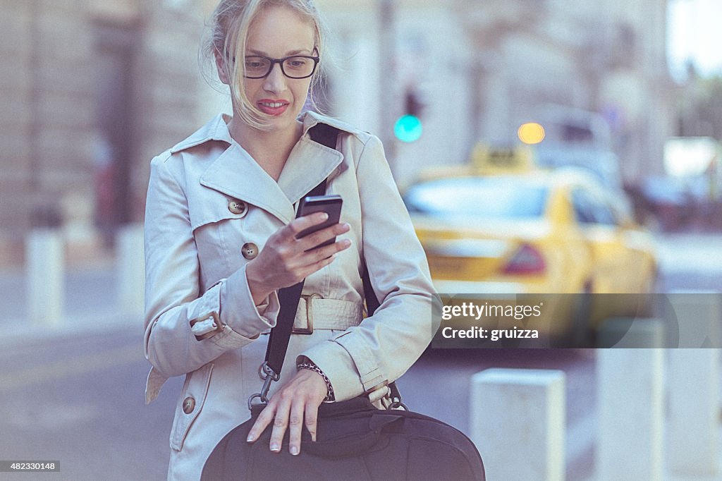 Jovem Empresária usando um telefone móvel em environmen urbana