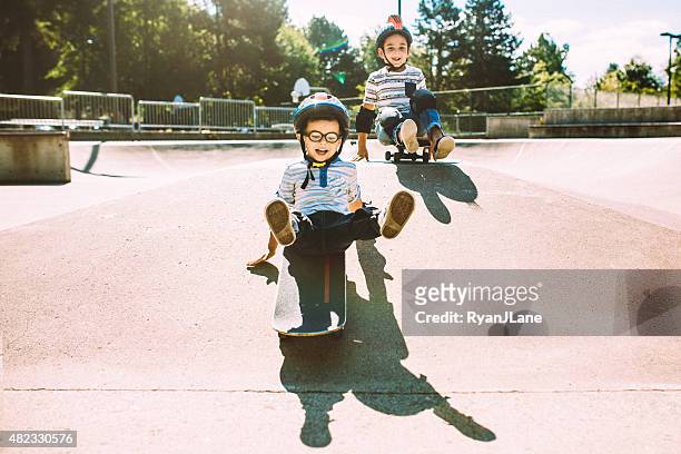 brothers riding skateboards at park - skatepark bildbanksfoton och bilder