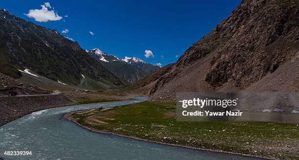 Vehicle passes on a highway nest to the Indus river flowing towards Pakistan administered Kashmir on July 30, 2015 in Drass, 142 km east of Srinagar...