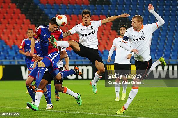 Fabian Schaer of Basel is challenged by Eduardo Vegas and Jeremy Mathieu of Valencia during the UEFA Europa League Quarter Final first leg match...