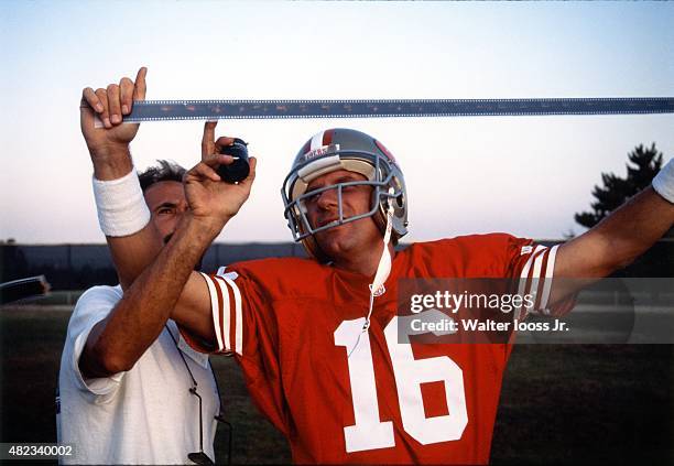 Portrait of San Francisco 49ers QB Joe Montana looking at film with Sports Illustrated via Getty Images photographer Walter Iooss Jr. During photo...