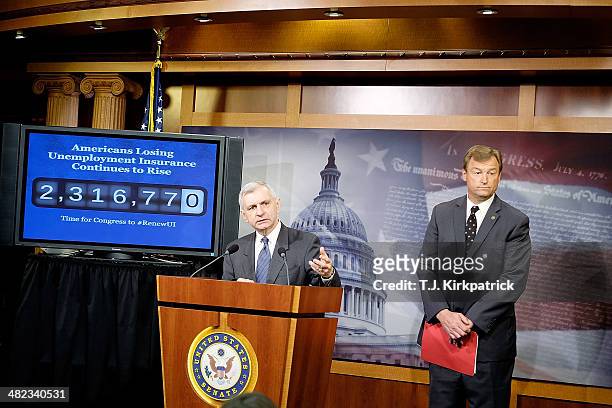 Senators Jack Reed , left, and Dean Heller , standing in front of a screen showing an increasing number count to represent the number of Americans...