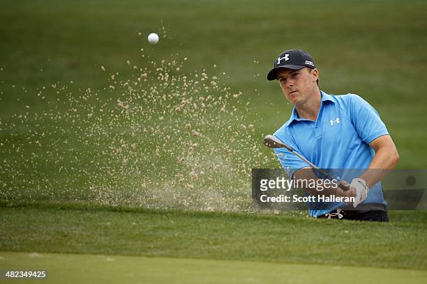 Jordan Spieth of the United States hits a shot out of the bunker on the eighth hole during round one of the Shell Houston Open at the Golf Club of...