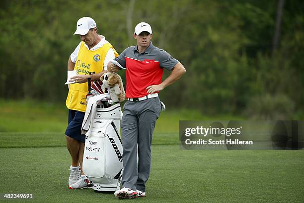 Rory McIlroy of Northern Ireland looks on with his caddy J.P. Fitzgerald on the second hole during round one of the Shell Houston Open at the Golf...