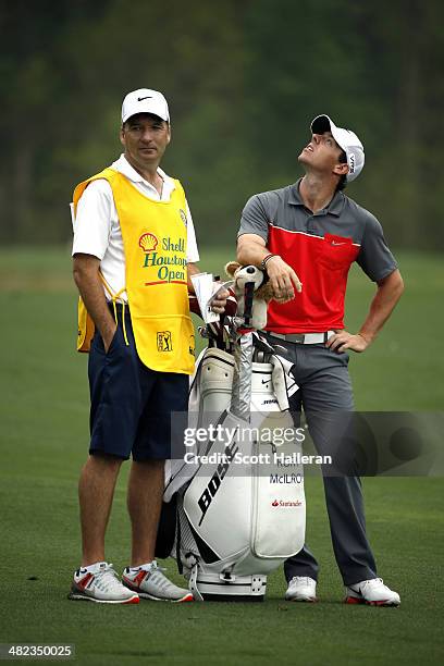Rory McIlroy of Northern Ireland looks up with his caddy J.P. Fitzgerald on the second hole during round one of the Shell Houston Open at the Golf...