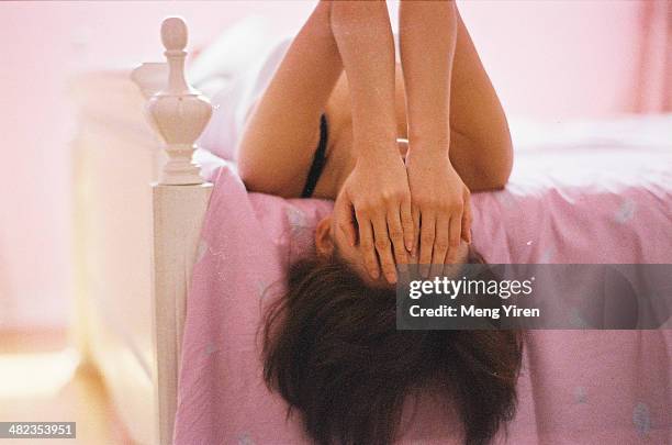 girl lying on the bed covering face by hand - arrossire foto e immagini stock