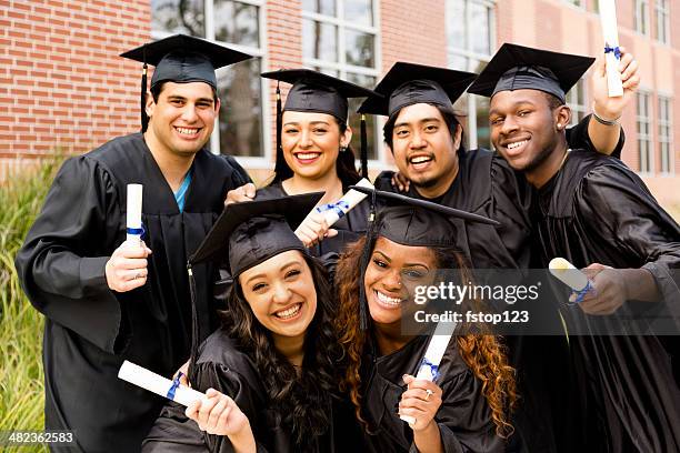 educaton: multiétnico amigos excitedly retención después de graduación de los diplomas universitarios. - graduación fotografías e imágenes de stock