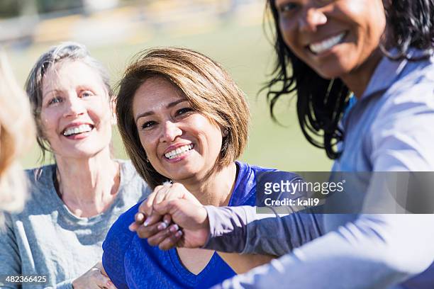 group of friends holding hands in park - only mature women stock pictures, royalty-free photos & images