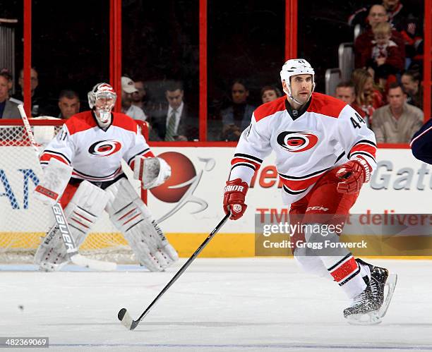 Jay Harrison of the Carolina Hurricanes skates into the defensive zone in front of teammate Anton Khudobin during their NHL game against the Columbus...