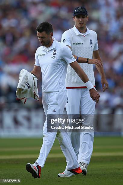 James Anderson of England heads towards the dressing room as Steven Finn looks on after pulling a side muscle during day two of the 3rd Investec...