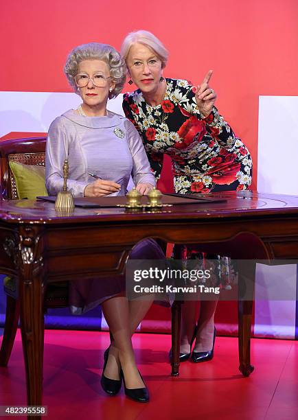 Dame Helen Mirren comes face to face with three waxwork figures of herself today at Madame Tussauds on July 30, 2015 in London, England.