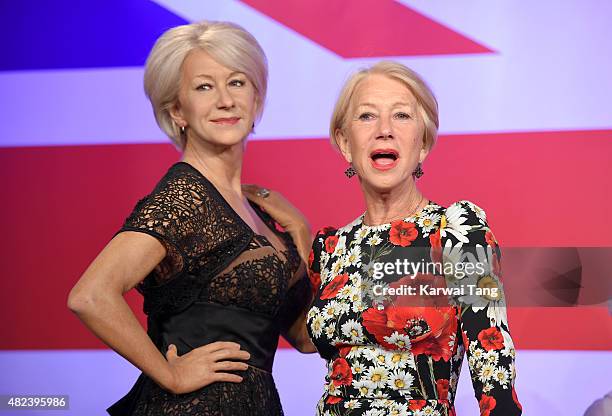 Dame Helen Mirren comes face to face with three waxwork figures of herself today at Madame Tussauds on July 30, 2015 in London, England.