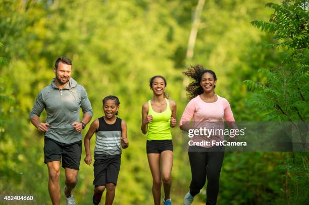 family jogging at the park - familie sport stockfoto's en -beelden