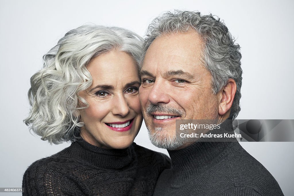 Mature couple smiling for camera, portrait.