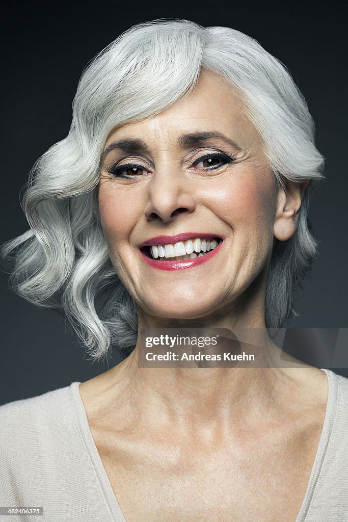 Sivery, grey haired woman with a big smile.