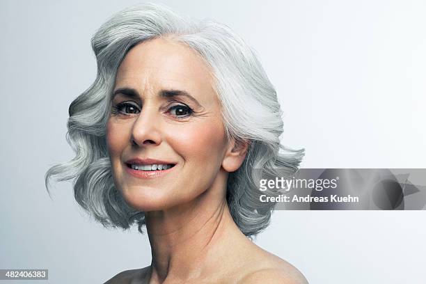 woman with wavy, grey hair smiling, portrait. - hair woman mature grey hair beauty stock pictures, royalty-free photos & images