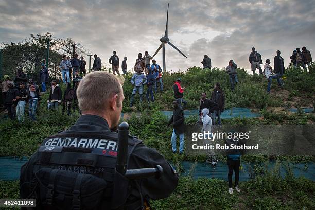Gendarmerie attempt to prevent people from entering the Eurotunnel terminal in Coquelles on July 30, 2015 in Calais, France. Hundreds of migrants are...
