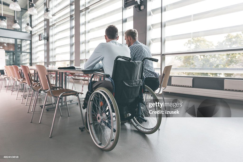 Behinderten Geschäftsmann arbeiten mit seinem Kollegen im Büro