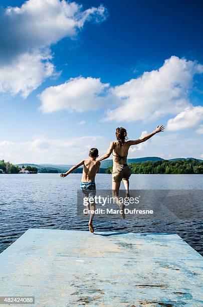 mother and son jumping in lake from dock - 11 loch stock pictures, royalty-free photos & images
