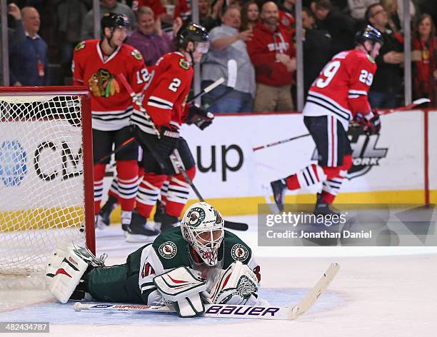 Ilya Bryzgalov of the Minnesota Wild lays on the ice after Bryan Bickell of the Chicago Blackhawks scored a goal in the third period at the United...