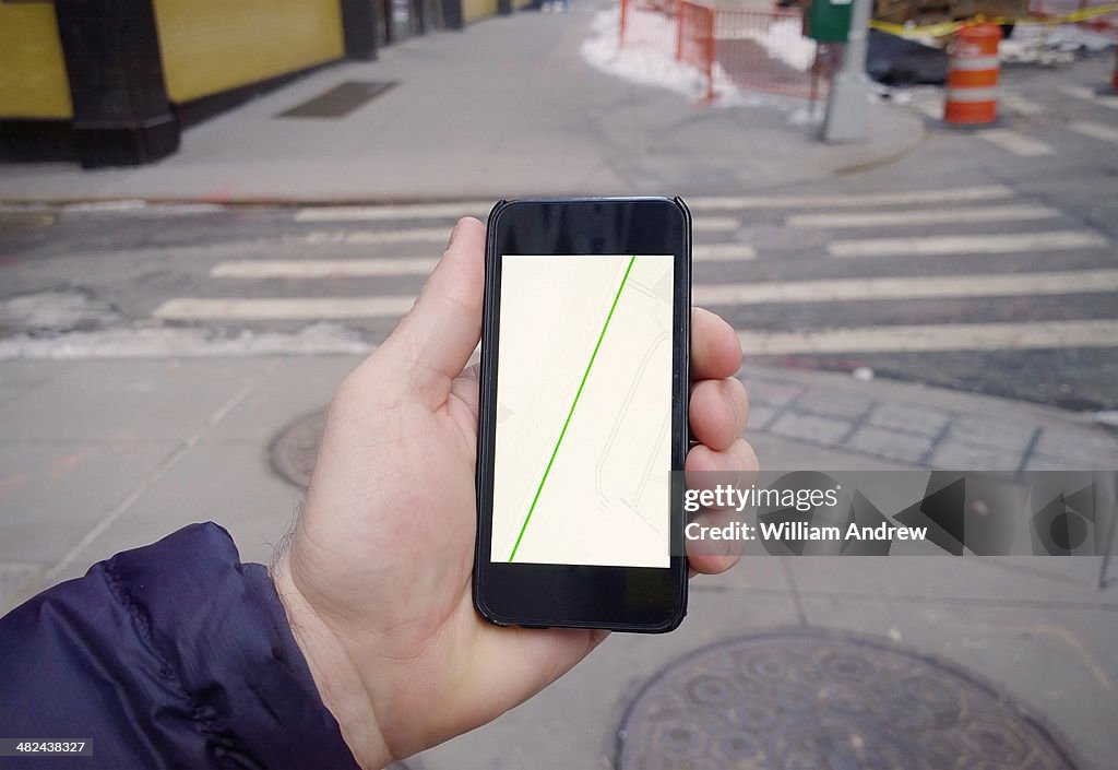 Hand holding phone with generic GPS directions