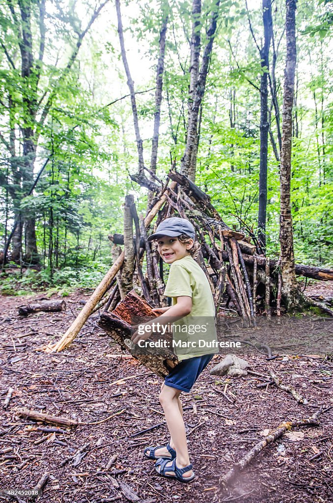 Kid building a shack in forest