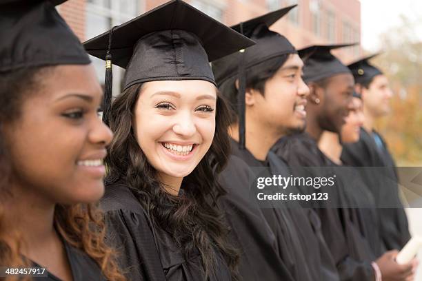 education: graduates stand in row on college campus. - graduation excitement stock pictures, royalty-free photos & images