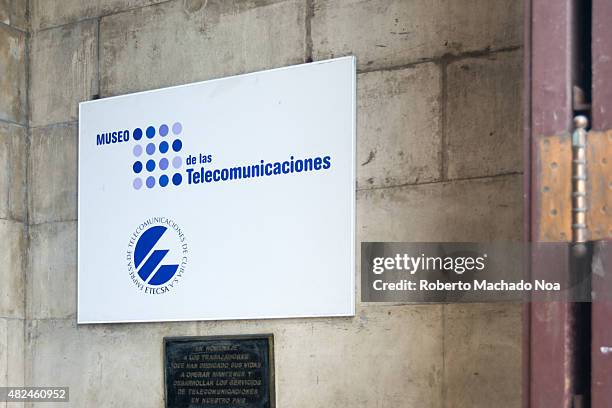 Sign advertising Museo de Las Telecomunicaciones, or the Museum of Telecommunications. The sign is white with a pattern of dots in shades of blue,...