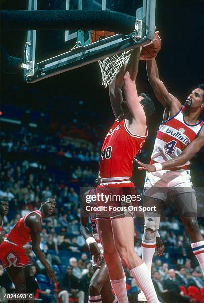 Dave Corzine of the Chicago Bulls has his shot blocked by Cliff Robinson of the Washington Bullets during an NBA basketball game circa 1985 at the...