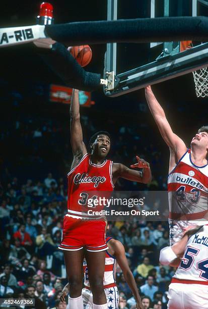 David Greenwood of the Chicago Bulls shoots over Jeff Ruland of the Washington Bullets during an NBA basketball game circa 1983 at the Capital Centre...