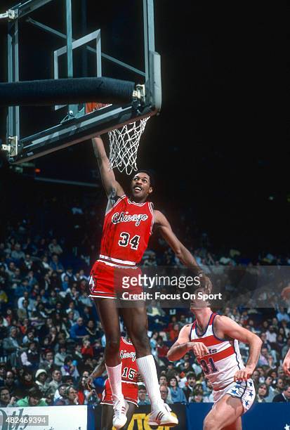 David Greenwood of the Chicago Bulls goes up for a slam dunk against the Washington Bullets during an NBA basketball game circa 1984 at the Capital...