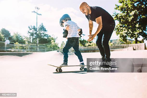 father and son at skate park - skateboarding stock pictures, royalty-free photos & images