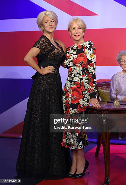 Dame Helen Mirren comes face to face with three waxwork figures of herself today at Madame Tussauds on July 30, 2015 in London, England.