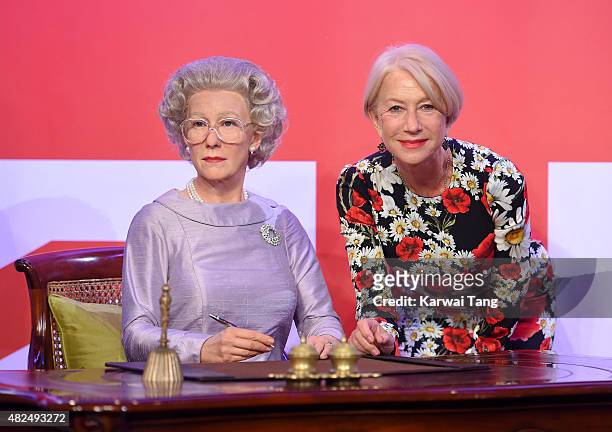 Dame Helen Mirren comes face to face with three waxwork figures of herself today at Madame Tussauds on July 30, 2015 in London, England.