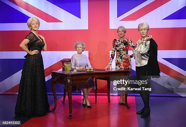 Dame Helen Mirren comes face to face with three waxwork figures of herself today at Madame Tussauds on July 30, 2015 in London, England.