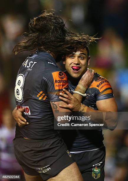 David Nofoaluma of the Tigers celebrates scoring a try with team mate Aaron Woods during the round 21 NRL match between the Wests Tigers and the...