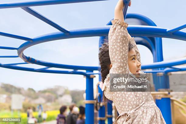 young girl swinging by monkey bars - michael virtue stock pictures, royalty-free photos & images