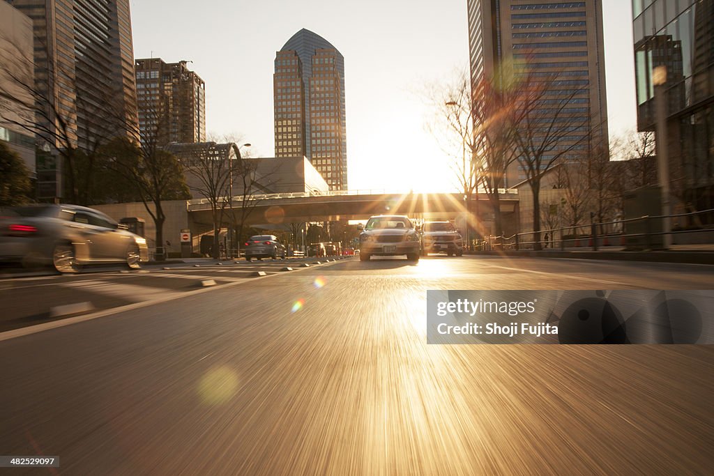 Road in city with car and sunlight