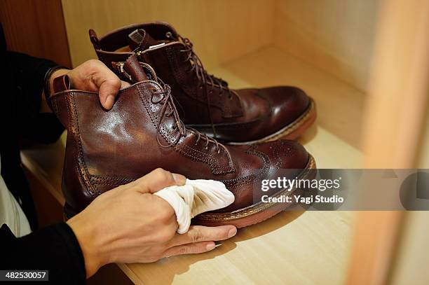 man polishing leather shoes - abrillantar fotografías e imágenes de stock