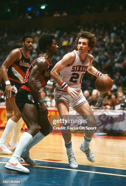 Doug Collins of the Philadelphia 76ers drives on T.R. Dunn of the Portland Trail Blazers during an NBA basketball game circa 1979 at The Spectrum in...