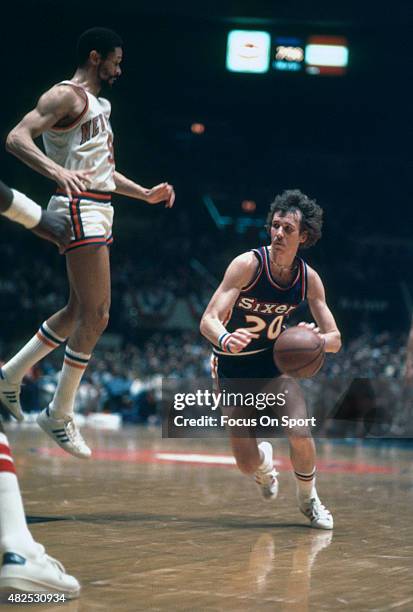 Doug Collins of the Philadelphia 76ers dribbles pass Butch Beard of the New York Knicks during an NBA basketball game circa 1976 at Madison Square...