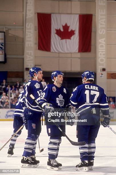 Doug Gilmour, Wendel Clark and Rob Pearson of the Toronto Maple Leafs talk on the ice during an NHL game against the Tampa Bay Lightning on March 18,...