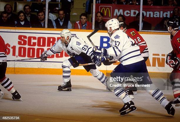 Doug Gilmour and Wendel Clark of the Toronto Maple Leafs go for the puck during an NHL game against the Chicago Blackhawks on April 12, 1994 at the...
