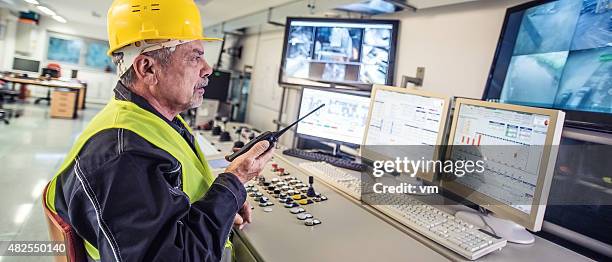 panoramic shot of technician in control room - walkie talkie stock pictures, royalty-free photos & images