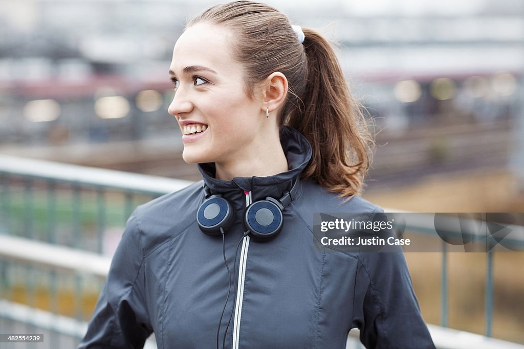 Sporty young girl smiling in front of city scape