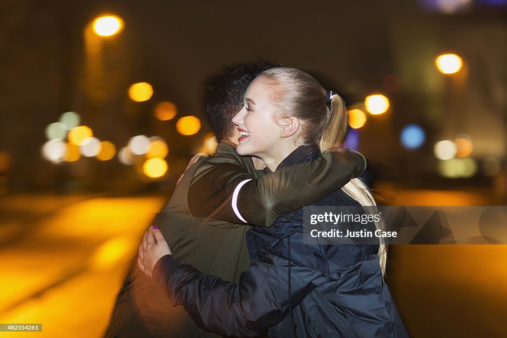 Sporty couple hugging each other at night