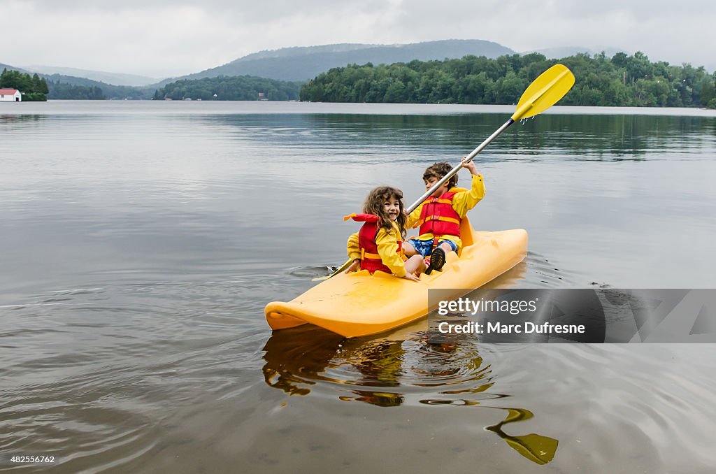 Young boy and girl, en kayak en un lago